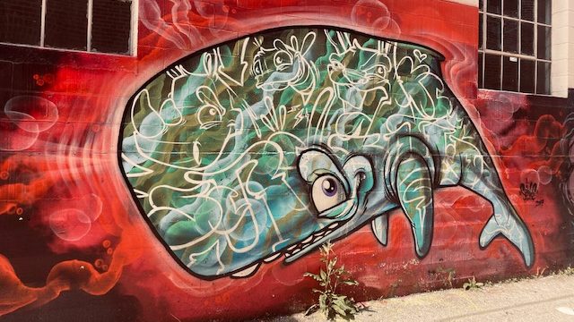 Whale mural stretched across a building wall in the Crossroads Arts District