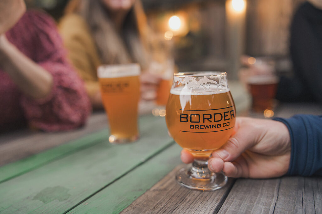 A picture of Border Brewing Company's NA brew, the Baseline Series in a glass on the patio