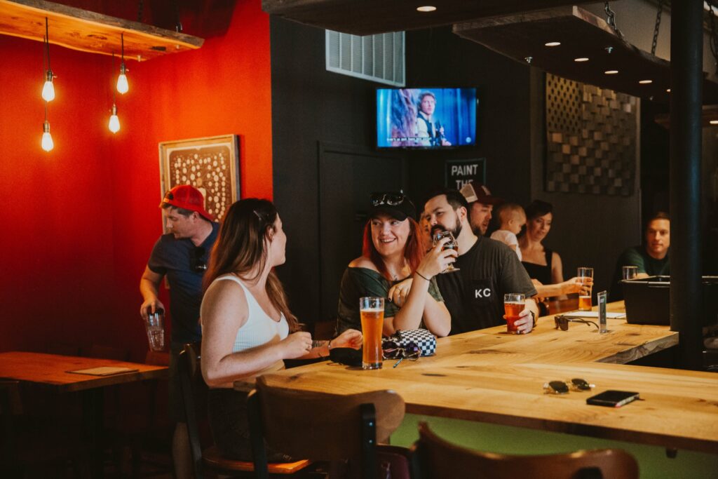 A happy group of customers drinking beers & cider from Border Brewing Company in the Kansas City Taproom